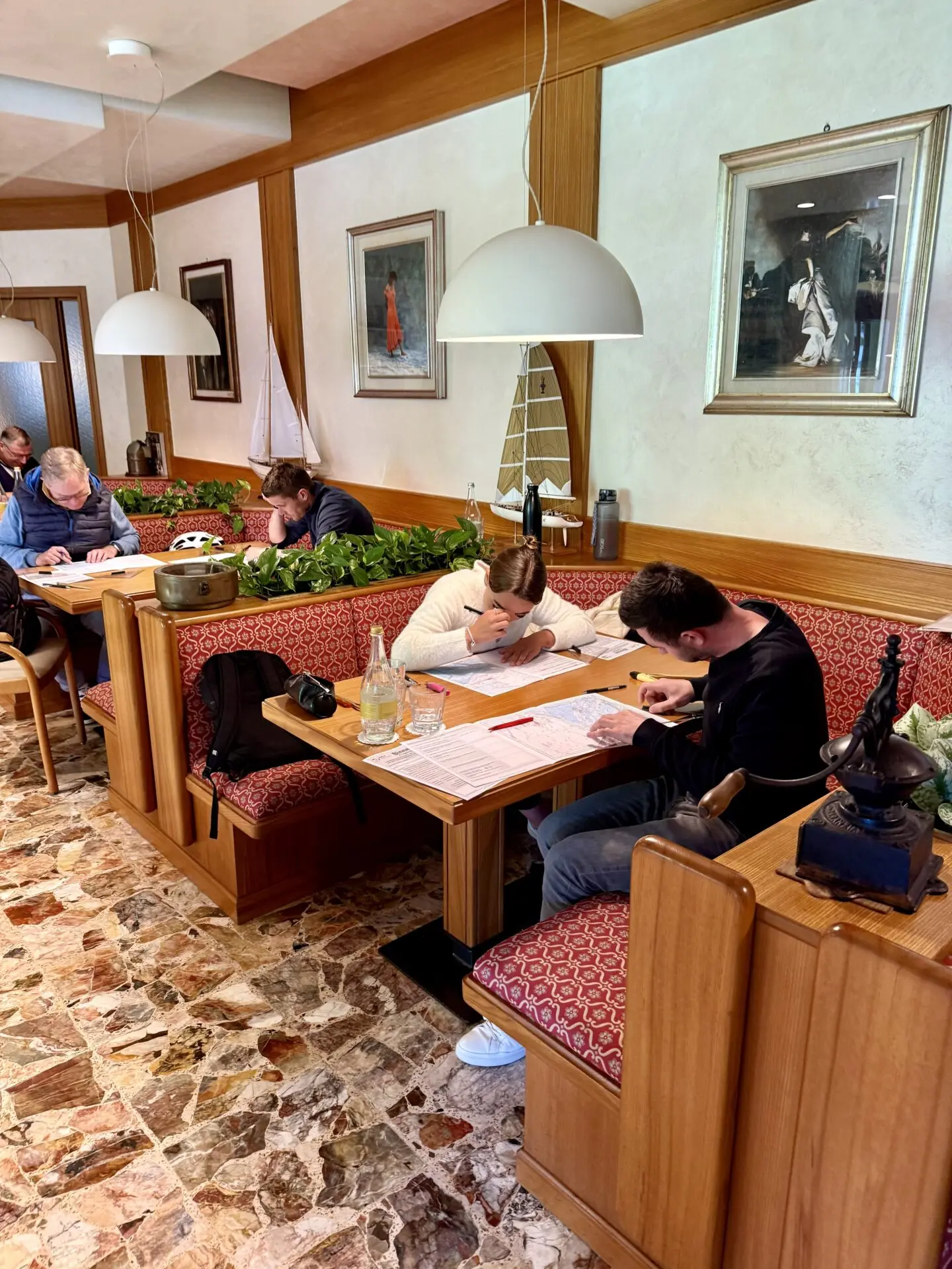 ab-sportbootschule_pruefung_30-04-2026_03 Im Hotel Garden Zorzi am Gardasee beantworten Teilnehmer der SBF-See-und-Binnen-Prüfung ihre Aufgaben und zeigen dem Prüfer ihr Wissen.