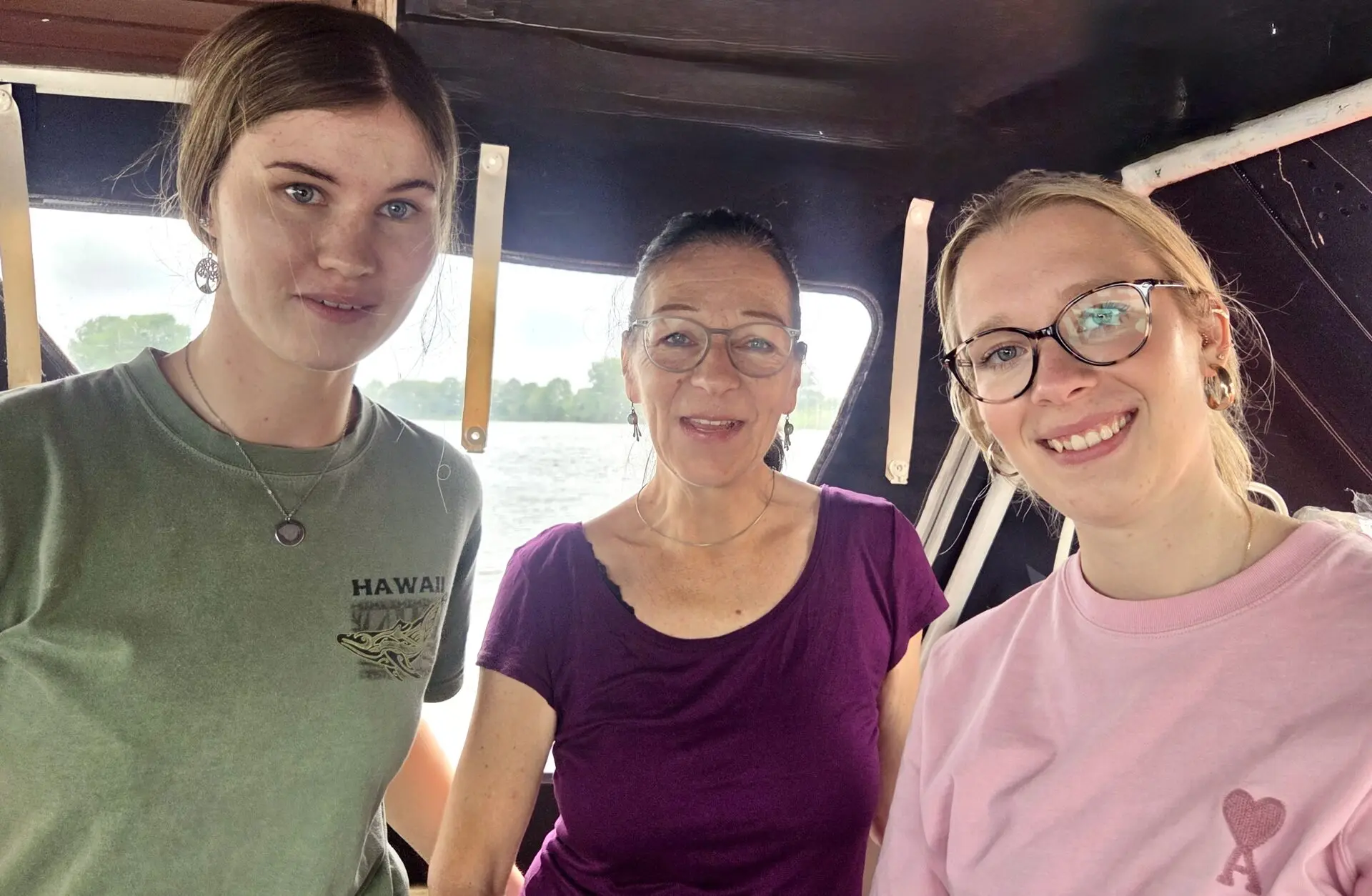 Drei lächelnde Frauen stehen in der Kabine eines Bootes vor dem Wasserblick auf der Weser nach der Prüfung.