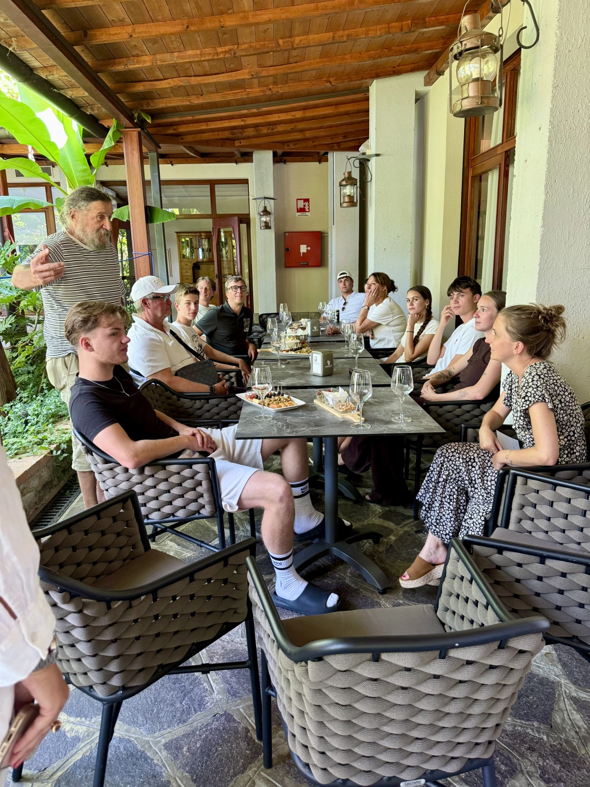Teilnehmer und Kursleiter der Bootsschule sitzen nach der Prüfung gemeinsam auf einer überdachten Terrasse in San Felice del Benaco