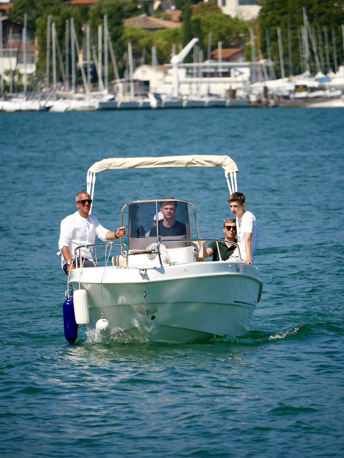Vier Teilnehmer fahren bei der Bootsprüfung auf dem Gardasee in San Felice del Benaco gemeinsam ein Motorboot.