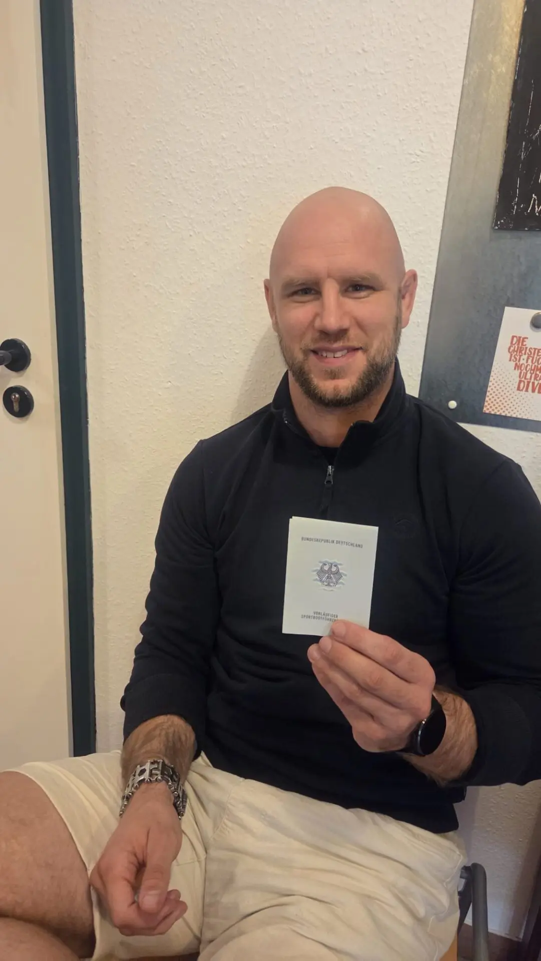 Ein Teilnehmer hält nach bestandener Sportbootführerschein-Prüfung an der Weser ein Prüfungsdokument in die Kamera.